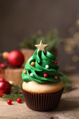 Fototapeta na wymiar Christmas tree shaped cupcake on wooden table