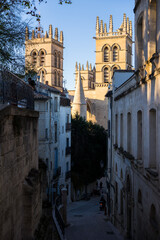 Tours de la Cathédrale de Montpellier émergeant depuis la Rue Saint-Pierre