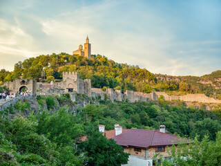 Veliko Tarnovo, Bulgaria - August 2022: Tourists in Veliko Tarnovo and the Eastern Orthodox Ascension Cathedral located in the famous medieval fortress Tsarevets in the background.