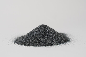 Silicon carbide powder close-up isolated on white background. Silicon carbide abrasive grit for restore stones to original flatness and leveling sharpening stones. - obrazy, fototapety, plakaty
