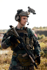 Serious soldier person with rifle during military operation, portrait, alone. Concept of military anti-terrorism operations, special operations of NATO forces. guy in combat wear looking down