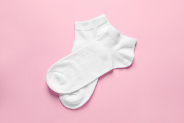 Pair of white socks on pink background, flat lay