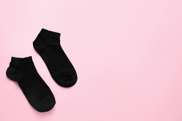 Pair of black socks on pink background, flat lay. Space for text