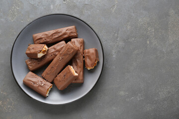 Tasty chocolate bars with caramel on grey table, top view. Space for text