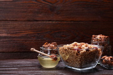 Tasty granola with nuts and dry fruits on wooden table. Space for text