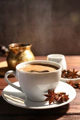 Fotobehang Cup of aromatic hot coffee with anise stars on wooden table © New Africa