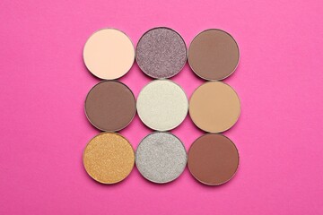 Beautiful eye shadow refill pans on pink background, flat lay