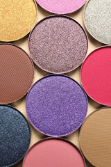 Different beautiful eye shadows on beige background, flat lay