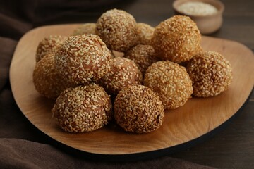 Many delicious sesame balls on wooden table, closeup