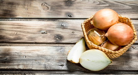 Fresh onions in a basket and slices of onion.