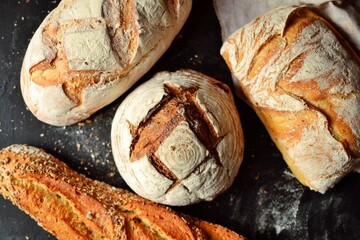 Bakery products. Crispy, beautiful bread on a dark background. Top view, place for text.