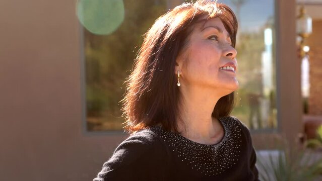 Attractive woman with dimples smiling head shot back lit blurred background