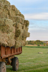 Selective focus of tractor trailer heavily loaded with hay bales in the countryside. Copy space.