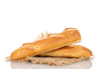 Two halves of a fresh fragrant baguette on a jute napkin, macro, isolated on a white background.