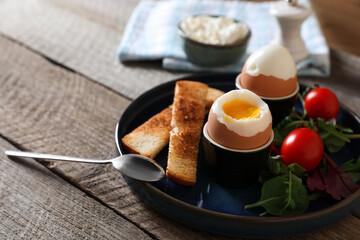 Delicious breakfast with soft boiled eggs served on wooden table, closeup