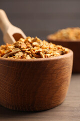 Bowls of dried orange zest seasoning on wooden table, closeup