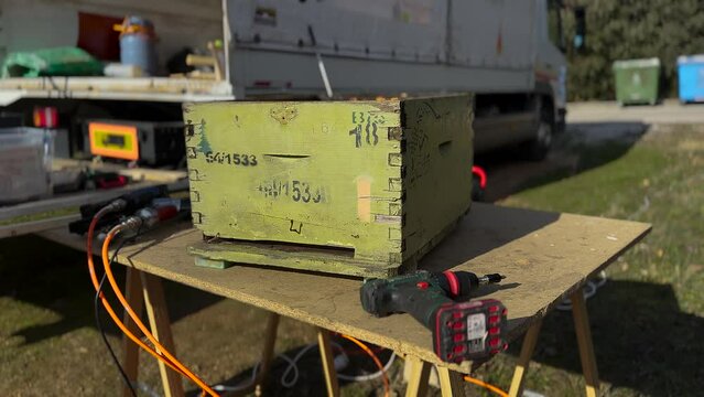 Carpenter Restoring Old Beehives Outside