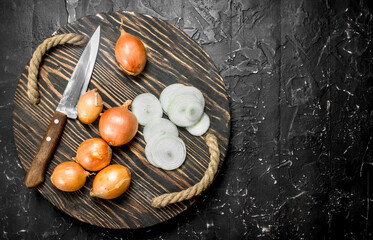 Rings and heads of onions on tray with a knife.