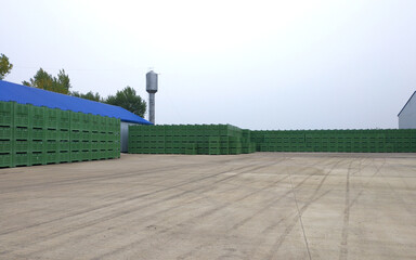 tall stacks of green plastic crates outdoors. containers for storing, collecting and sorting fruits and vegetables. large containers for products in a wholesale warehouse