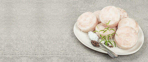 Chunks of frozen hake. Marine fish fillet on stone background, raw ingredient for cooking food