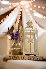 Purple bouquet and glass lantern wedding centrepiece