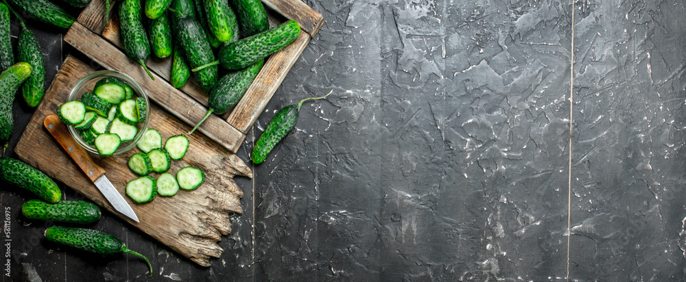 Poster Cucumbers on tray and cucumber slices on a cutting Board with a knife.