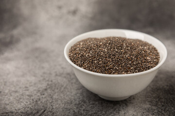 Chia seeds in a bowl on a textured black background. Diet food. Superfood. Healthy food. Space for text, copy space