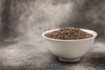 Chia seeds in a bowl on a textured black background. Diet food. Superfood. Healthy food. Space for text, copy space