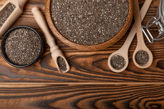 Chia seeds in bowl and spoons on brown wood texture. Diet food. Superfood. Healthy food. Space for text, copy space © Avocado_studio