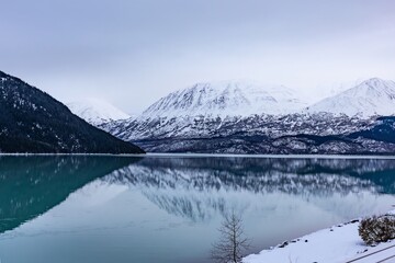 reflecting lake in the foggy Alaskan mountains outside of Seward Alaska in winter snow