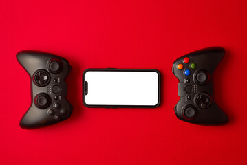Modern black gamepad for smartphone on red background. Mobile video gaming device © stenkovlad