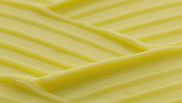 Macro crane shot of yellow moisturizing cream with shea butter wave texture | Moisturizing cream background shot for its commercial
