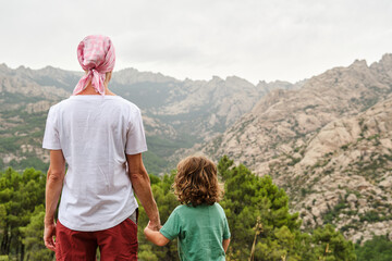 A Woman with pink scarf against breast cancer in nature with her son
