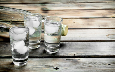 Vodka in a bottle and glasses with ice.