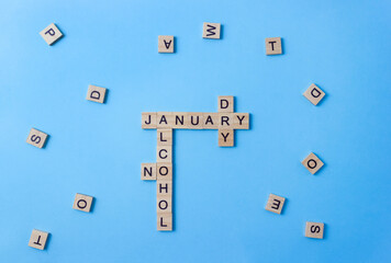 Words Dry January and No Alcohol made up of wooden blocks with letters. Concept of sobriety and abstinence after New Year holidays. Alcohol-free challenge