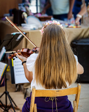 Girl plays the violin at a fair