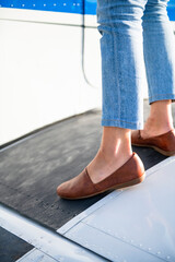 Young BIPOC Female Pilot stepping onto small plane wing