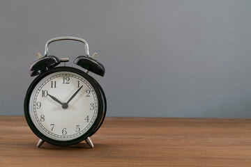 Retro alarm clock on gray table background, vintage style.