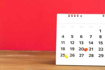 close up of calendar on the red table background, planning for business meeting or travel planning concept