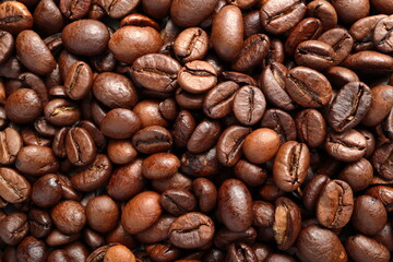 Close-up macro shot of the coffee beans lying on a flat surface. The photo shows the fine details and the texture of the product and can be used as a background.