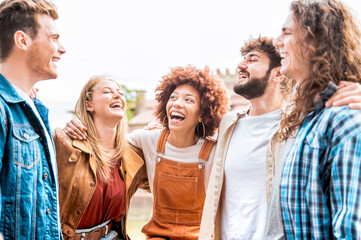 Happy smiling friends having fun together outdoors - Mixed race  group of people enjoying a holiday day out together - Happy lifestyle, youth and young team concept.