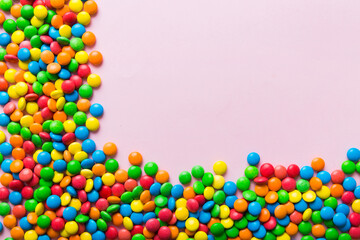 Mixed collection of colorful candy, on colored background. Flat lay, top view. frame of colorful chocolate coated candy