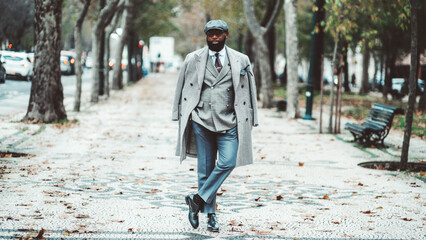 A mature African male with an unshaven black beard looking dapper in an elegant wool coat, beret,...