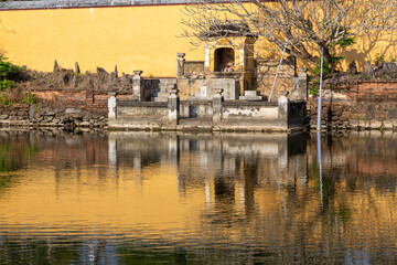 Sunlight Reflecting of Ancient Imperial City Citadel in Hue Vietnam with Calm Water Lagoon In Foreground