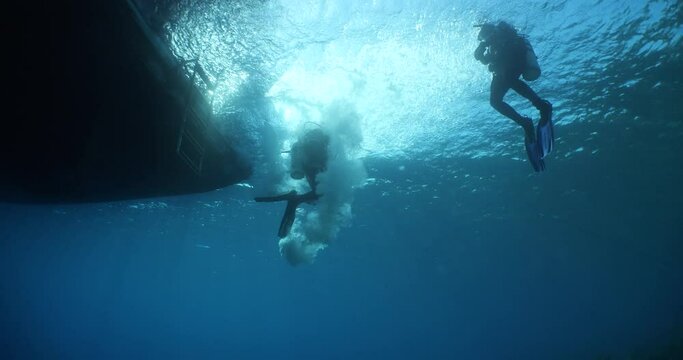 boat underwater scuba diver jumps into water ocean scenery