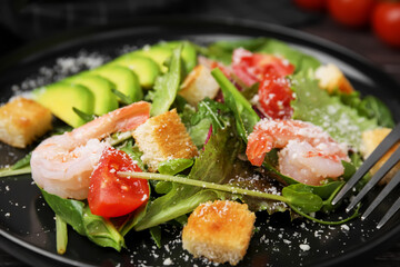 Delicious salad with croutons, avocado and shrimp served on table, closeup
