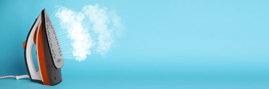Modern iron with steam on light blue background, space for text. Banner design