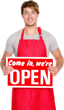 Business owner / employee showing open sign. Man wearing red apron smiling happy. Caucasian male model.