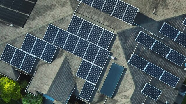 Aerial view of typical american building roof with rows of blue solar photovoltaic panels for producing clean ecological electric energy. Renewable electricity with zero emission concept
