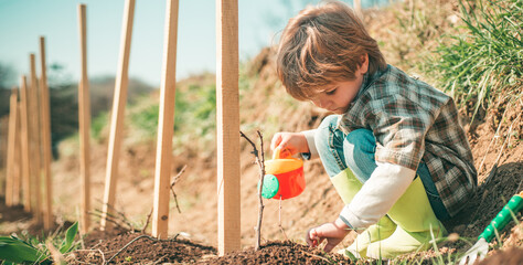 Spring banner. Little farmer with Shovel and watering can. Little helper in garden Planting flowers. Child Farmer planting in the vegetable garden. © Volodymyr
